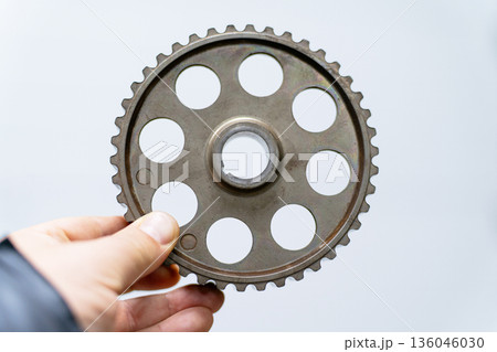 The mechanic's hand holds a gear The mechanic's hand holds a gear 136046030