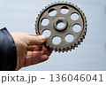 The hand of a master holds a gear 136046041