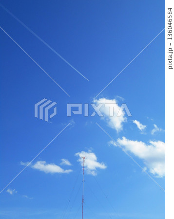 青空を貫く一筋の飛行機雲と白い雲 136046584