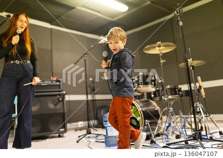 Boy and woman singing song in music studio Boy and woman singing song in music studio 136047107