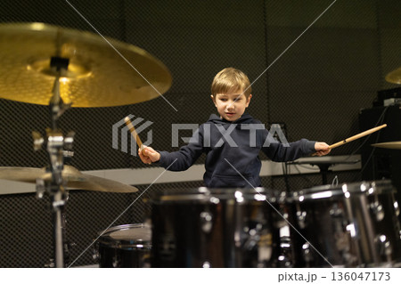 Young boy learning playing drums in music studio 136047173