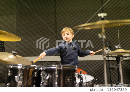 Young boy learning playing drums musical instrument 136047229