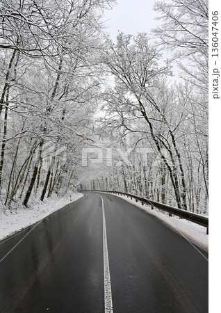 Snowy winter road. Dangerous car driving in the mountains in the winter. Concept for transportation, cars and travel. Snowy winter road. Dangerous car driving in the mountains in the winter. Concept for transportation, cars and travel. 136047406