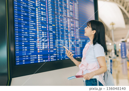 空港で電光掲示板を確認する女性　「撮影協力：関西国際空港（KIX）」 136048140