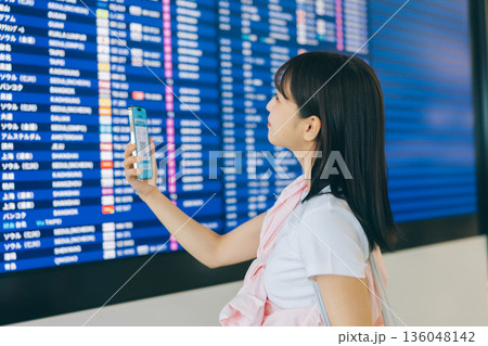 空港で電光掲示板を確認する女性 「撮影協力:関西国際空港(KIX)」 空港で電光掲示板を確認する女性 「撮影協力:関西国際空港(KIX)」 136048142