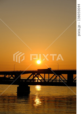しずむ夕日に照らされる橋を渡るトラック しずむ夕日に照らされる橋を渡るトラック 136050044