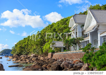 Iceland Phu Quoc Vietnam 5.7.2025. A house with a white roof sits on a hill overlooking a body of water Iceland Phu Quoc Vietnam 5.7.2025. A house with a white roof sits on a hill overlooking a body of water 136050107