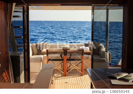 Luxury boat interior with sofa, galley, and sea view 136050145