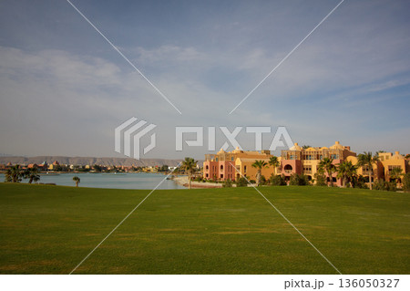 El Gouna Egypt 2.11.2025. A large green field with a lake in the background El Gouna Egypt 2.11.2025. A large green field with a lake in the background 136050327