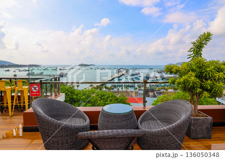A view of the ocean from a balcony with two chairs and a table A view of the ocean from a balcony with two chairs and a table 136050348