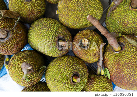 A bunch of green fruit with brown spots 136050351