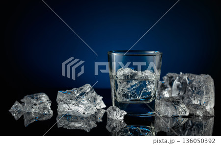 Crystal clear vodka or gin in a glass with ice. Crystal clear vodka or gin in a glass with ice. 136050392