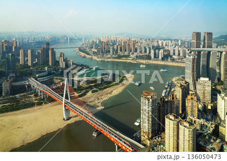 Chongqing China 4.7.2025. A city with a river running through it and a bridge over it Chongqing China 4.7.2025. A city with a river running through it and a bridge over it 136050473