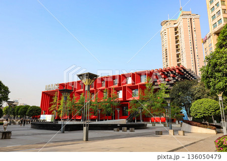 Chongqing China 4.7.2025. A red building with a green roof and a large green tree in front of it 136050479
