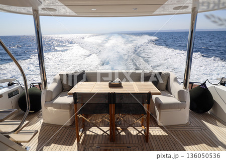A boat with a table and chairs on the deck 136050536