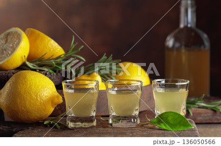 Italian liqueur Limoncello with fresh lemons and rosemary branches. 136050566
