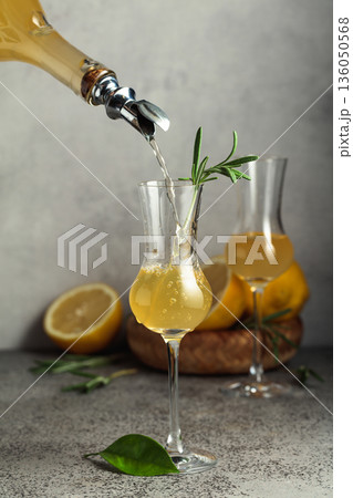 Italian liqueur Limoncello with fresh lemons and rosemary branches. Italian liqueur Limoncello with fresh lemons and rosemary branches. 136050568