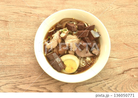 vermicelli thin rice noodles with pork and entrails topping egg yolk in soup on bowl 136050771