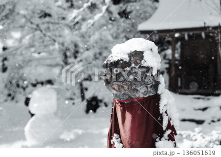 雪に包まれた石像と赤い前掛けの冬景色 雪に包まれた石像と赤い前掛けの冬景色 136051619