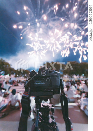夜空の花火と三脚に据えられたカメラ 136052064