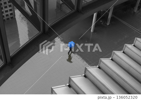 雨の日の都市空間を歩く青い傘の人物 136052320