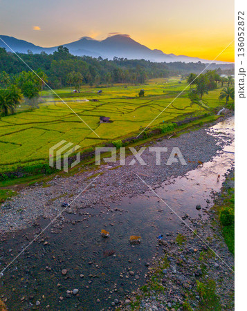 Beautiful morning view in Indonesia, panoramic landscape of rice fields with mountain ranges and clear sky Beautiful morning view in Indonesia, panoramic landscape of rice fields with mountain ranges and clear sky 136052872