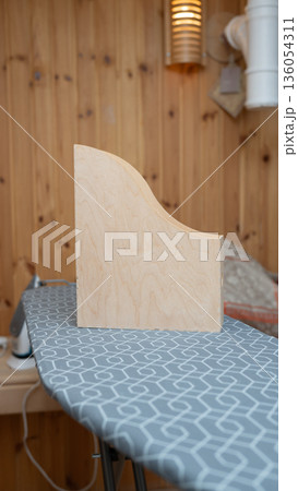 Wooden bookend on geometric patterned ironing board in cozy room 136054311