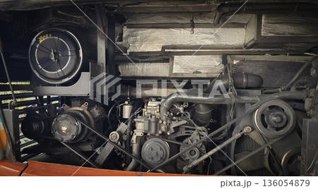 detailed view of a double decker bus engine bay showing belts, pulleys, radiator and hoses. Perfect for automotive maintenance, repair, and mechanical parts themes, conveys industry, repair work, and detailed view of a double decker bus engine bay showing belts, pulleys, radiator and hoses. Perfect for automotive maintenance, repair, and mechanical parts themes, conveys industry, repair work, and 136054879