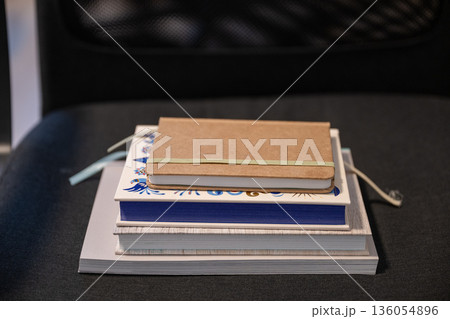 Minimal stack of notebooks and sketchbooks on dark background Minimal stack of notebooks and sketchbooks on dark background 136054896