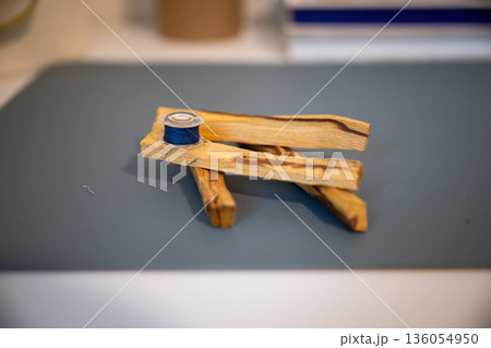 Minimal still life with wooden sticks and blue thread spool creating calm handmade craft composition Minimal still life with wooden sticks and blue thread spool creating calm handmade craft composition 136054950