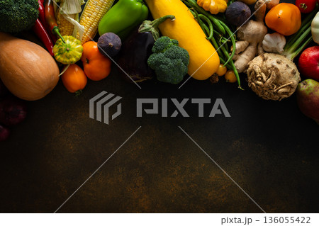 Fresh vegetables and fruits are arranged on a dark surface, showing a variety of colors and shapes. This was captured after a recent harvest from a local farm Fresh vegetables and fruits are arranged on a dark surface, showing a variety of colors and shapes. This was captured after a recent harvest from a local farm 136055422