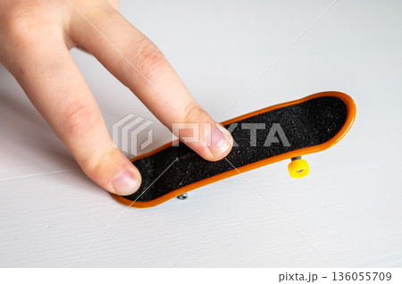 children's hands playing with a toy fingerboard, developing fine motor skills, selective focus 136055709