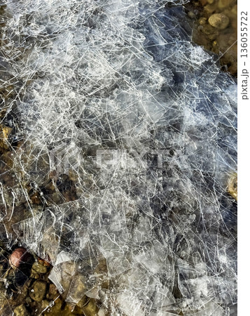 fragile cracked ice on the rocky shore of the lake fragile cracked ice on the rocky shore of the lake 136055722