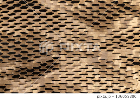 yellow paper with a lot of cuts is used for packaging and decorative purposes, paper with cuts and a lot of holes is used for packaging goods and other purposes 136055880
