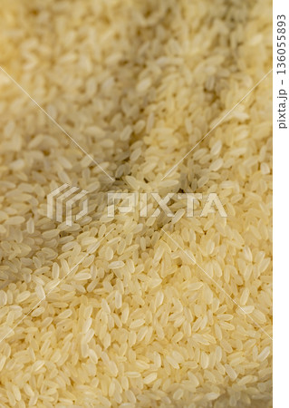 white dry hard rice, sprinkled before cooking, sprinkled with natural pure rice on the table before cooking, a large amount of pure high quality natural rice grains white dry hard rice, sprinkled before cooking, sprinkled with natural pure rice on the table before cooking, a large amount of pure high quality natural rice grains 136055893