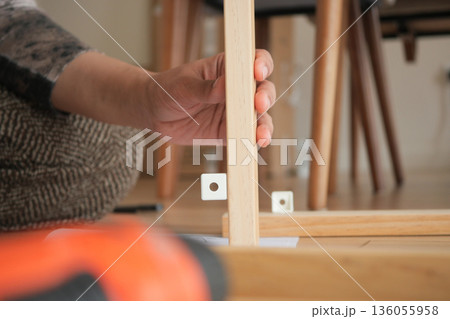 Building furniture by hand in a simple room 136055958