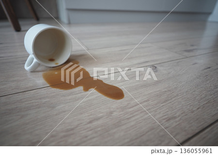 Spilled coffee on the wooden floor at home Spilled coffee on the wooden floor at home 136055961