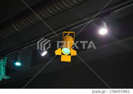 Stage lighting setup in a dark space with colored lights 136055962