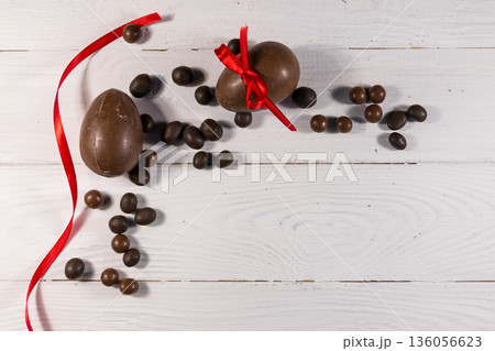 Easter composition with chocolate eggs on white wooden background 136056623