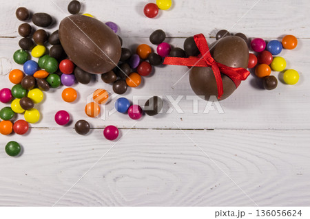 Easter composition with chocolate eggs on white wooden background 136056624