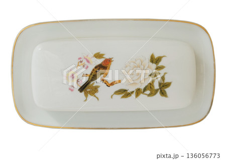 Porcelain dish for butter with a pattern of birdie isolated on a white background. Butter crock. Ornate ceramic dinnerware. Top view. 136056773