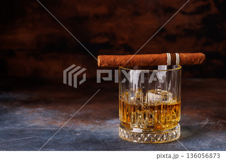Glass of whiskey with ice and cigar 136056873