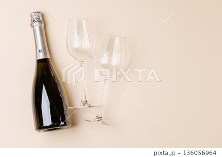 Champagne bottle and glasses on beige background Champagne bottle and glasses on beige background 136056964