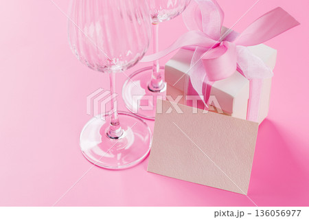 Gift box and wine glasses on pink background 136056977