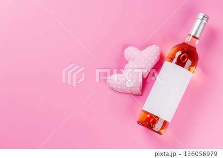 Rose wine and heart toys on pink background Rose wine and heart toys on pink background 136056979