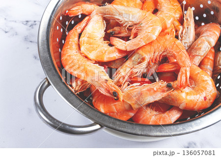 freshly frozen shrimp in a metal colander, for cooking, top view, close-up, on a marble table, no people, 136057081