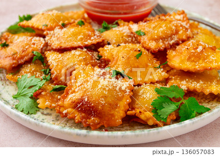 fried ravioli with parmesan cheese, served with red sauce and garnished with herbs, on a light background, no people, fried ravioli with parmesan cheese, served with red sauce and garnished with herbs, on a light background, no people, 136057083