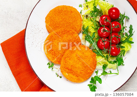 crispy fried fish cutlets, fish burgers, on a white plate, with fresh lettuce leaves, arugula and cherry tomatoes, homemade, no people, 136057084
