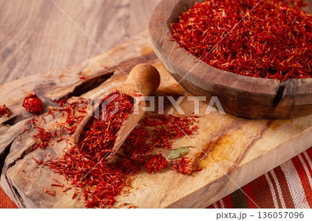 Spice saffron threads, in a wooden bowl, on a wooden table, top view, close-up, Spice saffron threads, in a wooden bowl, on a wooden table, top view, close-up, 136057096