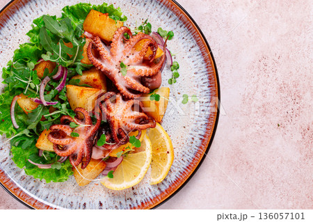 Grilled octopus with baked potatoes and fresh herbs, on a decorative plate, homemade, 136057101
